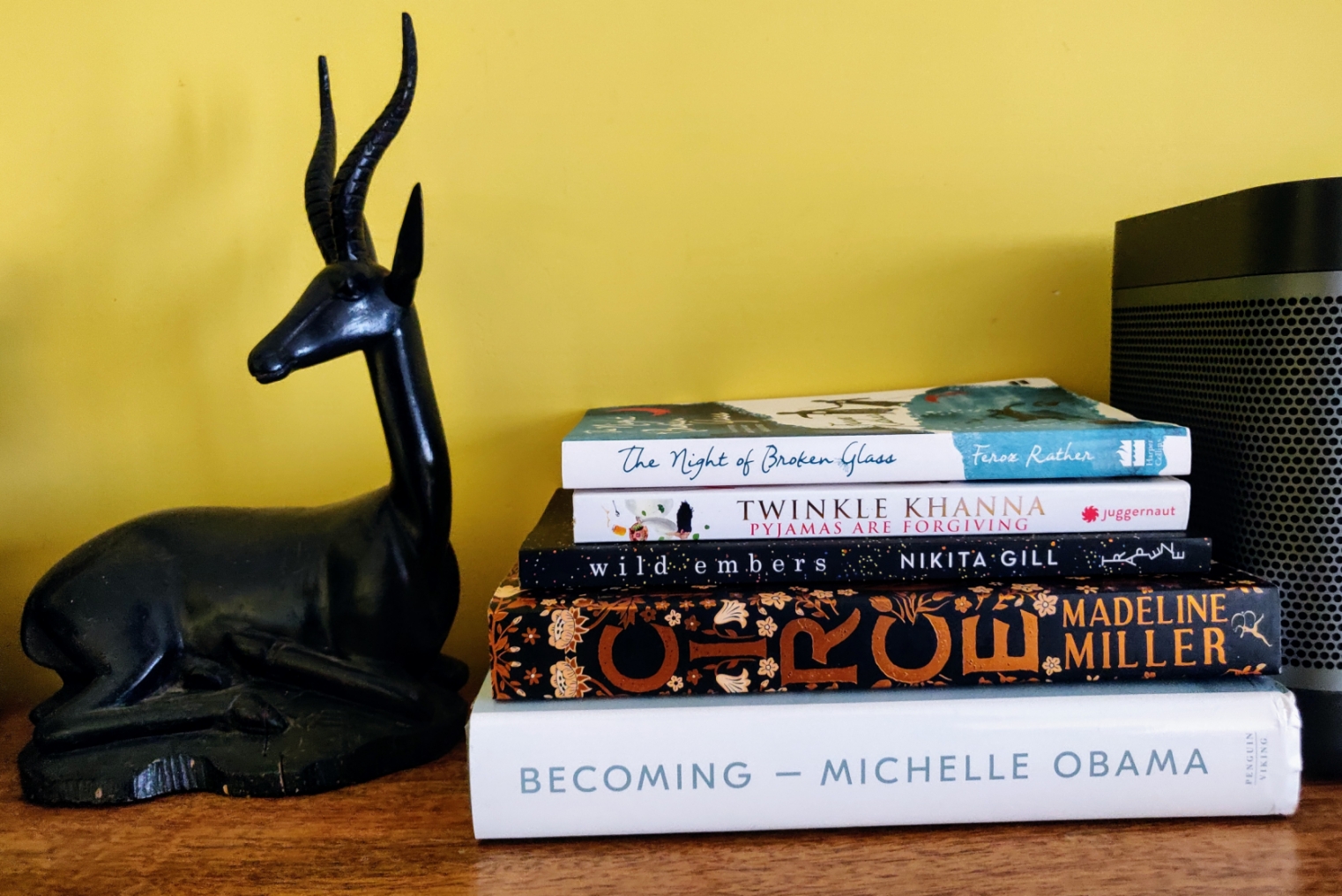 Pile of books next to a small wooden deer