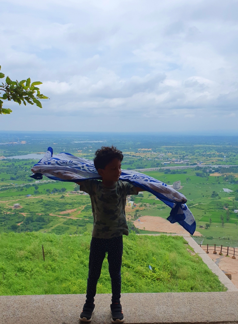 Child with fluttering scarf pretending to fly with the breeze at Bhongir Fort