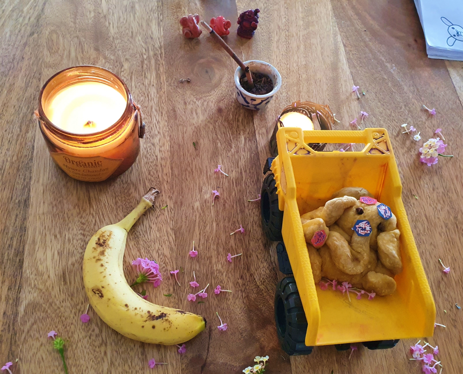 Eco friendly Ganesha mandap with flowers, candle, banana and homemade ganesha idol in a kid's toy truck