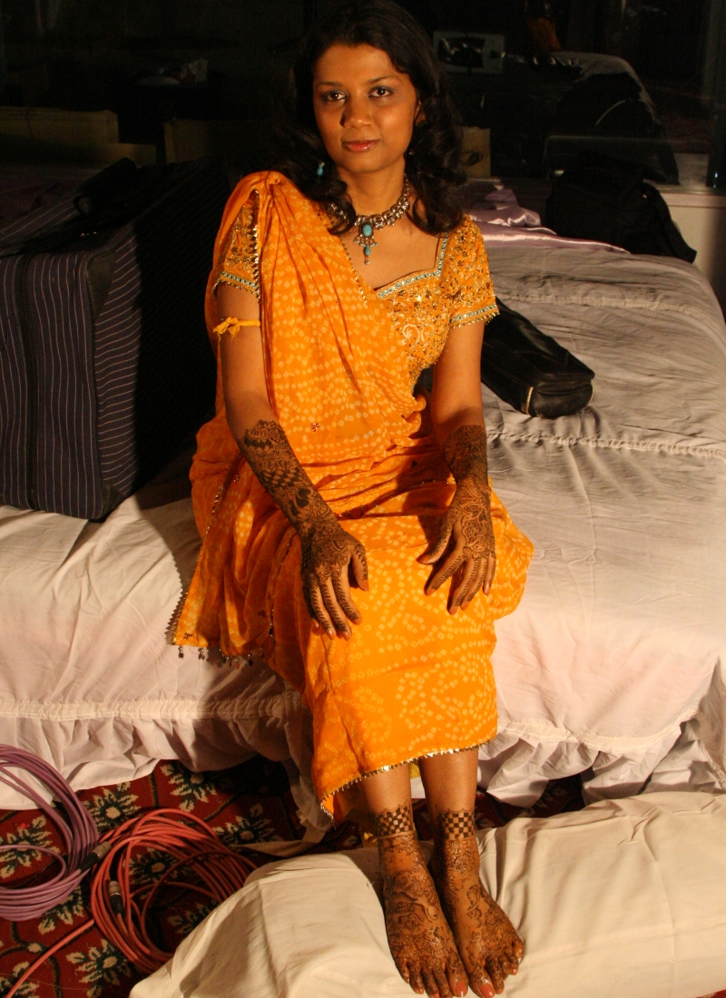 bride in yellow sari with bridal henna on her hands and feet