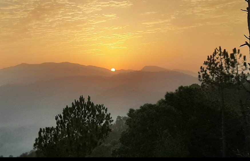 Sunset view over the hills with bright orange skies
