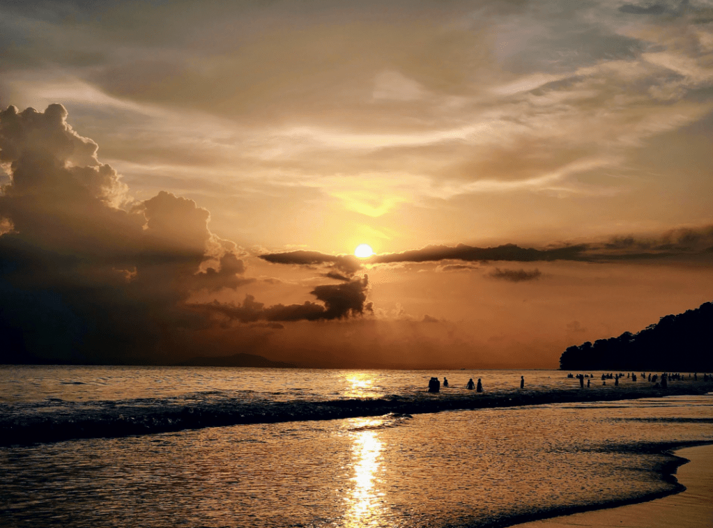sunset in oranges and browns with the calm waters reflecting the light