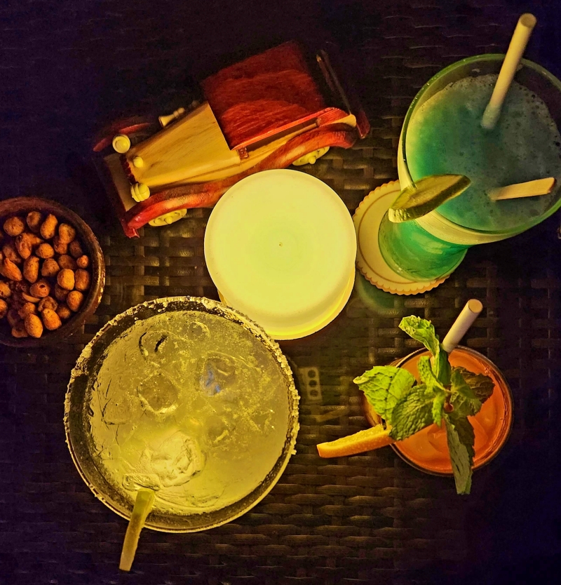 top view of cocktail glasses with a round table light and toy wooden car in dim night light
