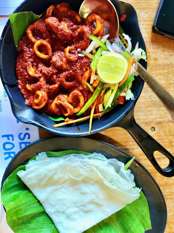 squid ghee roast in a pan with neer dosa