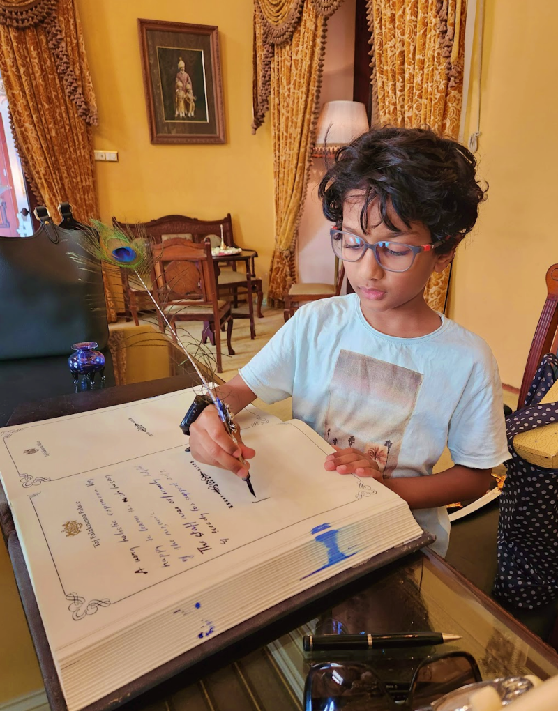 child writing in a guest book with a feather quill