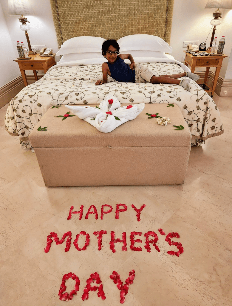 hotel bedroom with happy mother's day written in rose petals