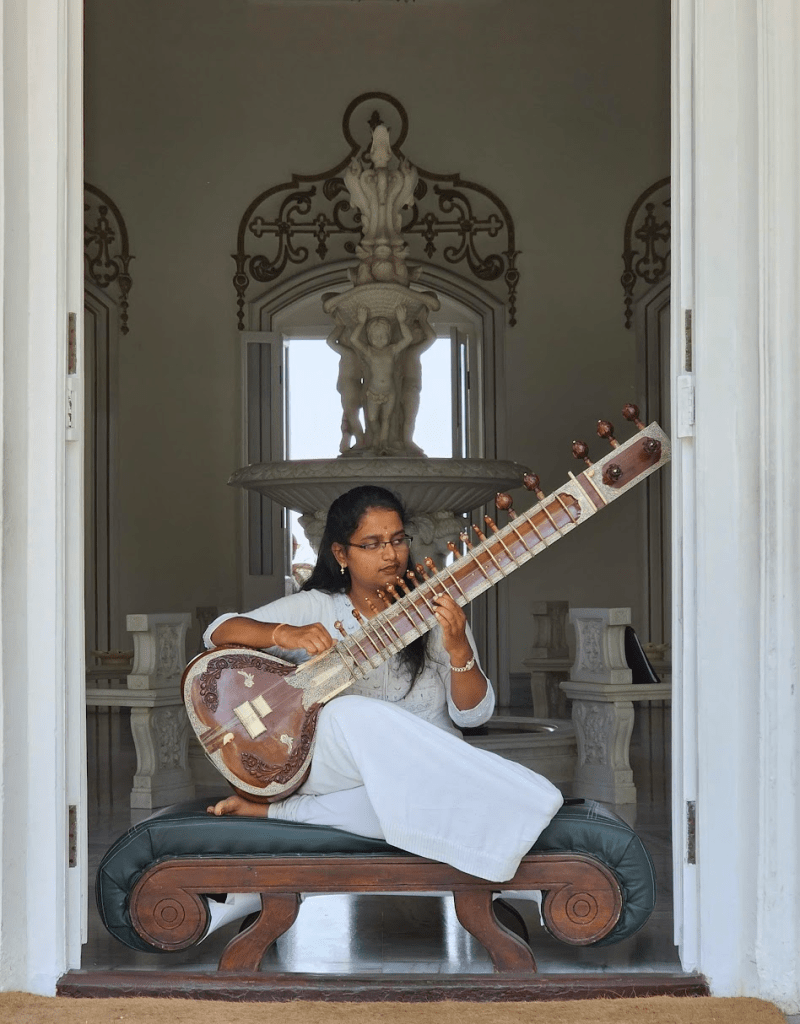 woman in white playing the sitar