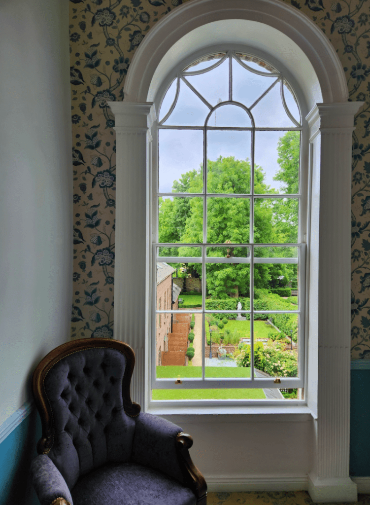 large window with chair with a garden outside at Stauntons on the Greens