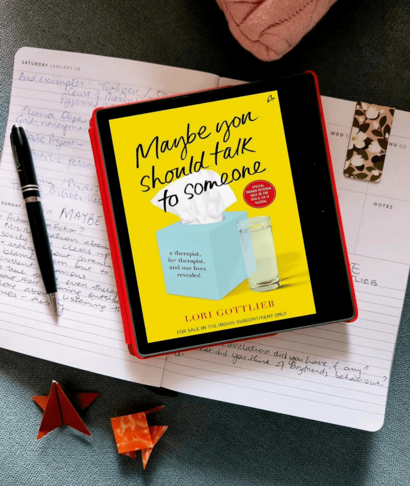 kindle book Maybe You Should Talk to Someone by Lori Gottlieb placed on a notebook taking notes for book club meeting