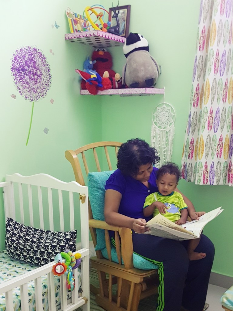 mom and baby reading before bedtime in rocking chair in the nursery