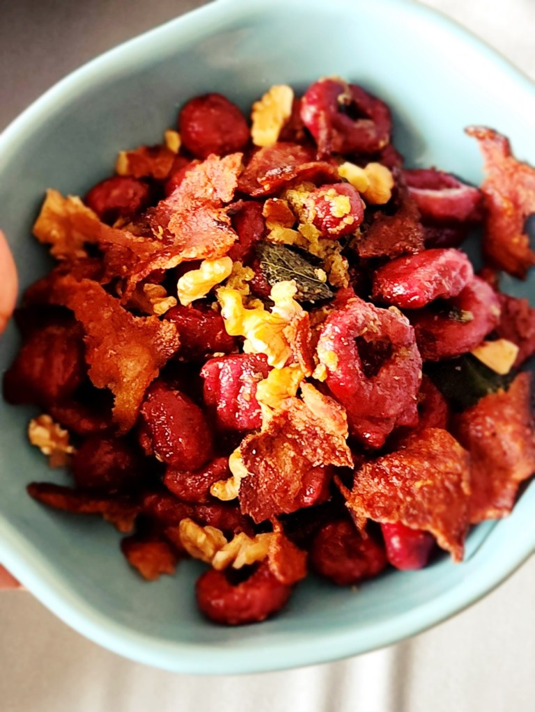 bowl of homemade beetroot gnocchi with sage, walnut and bacon